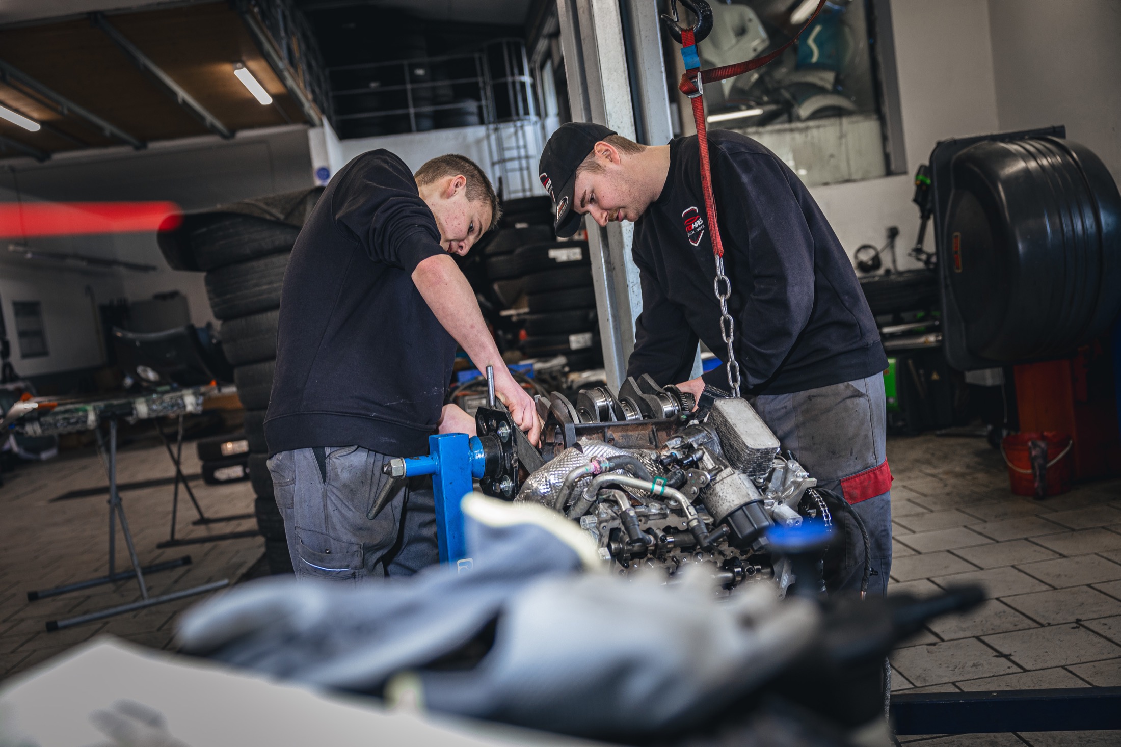 Teamarbeit in der Werkstatt bei der gemeinsamen Arbeit am Motor